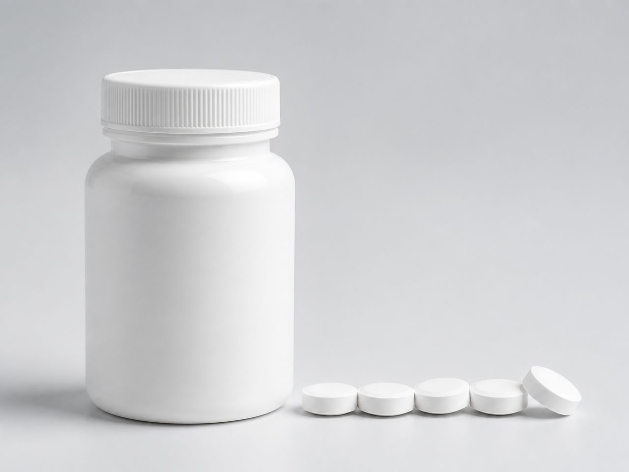 White supplement tablets beside a bottle
